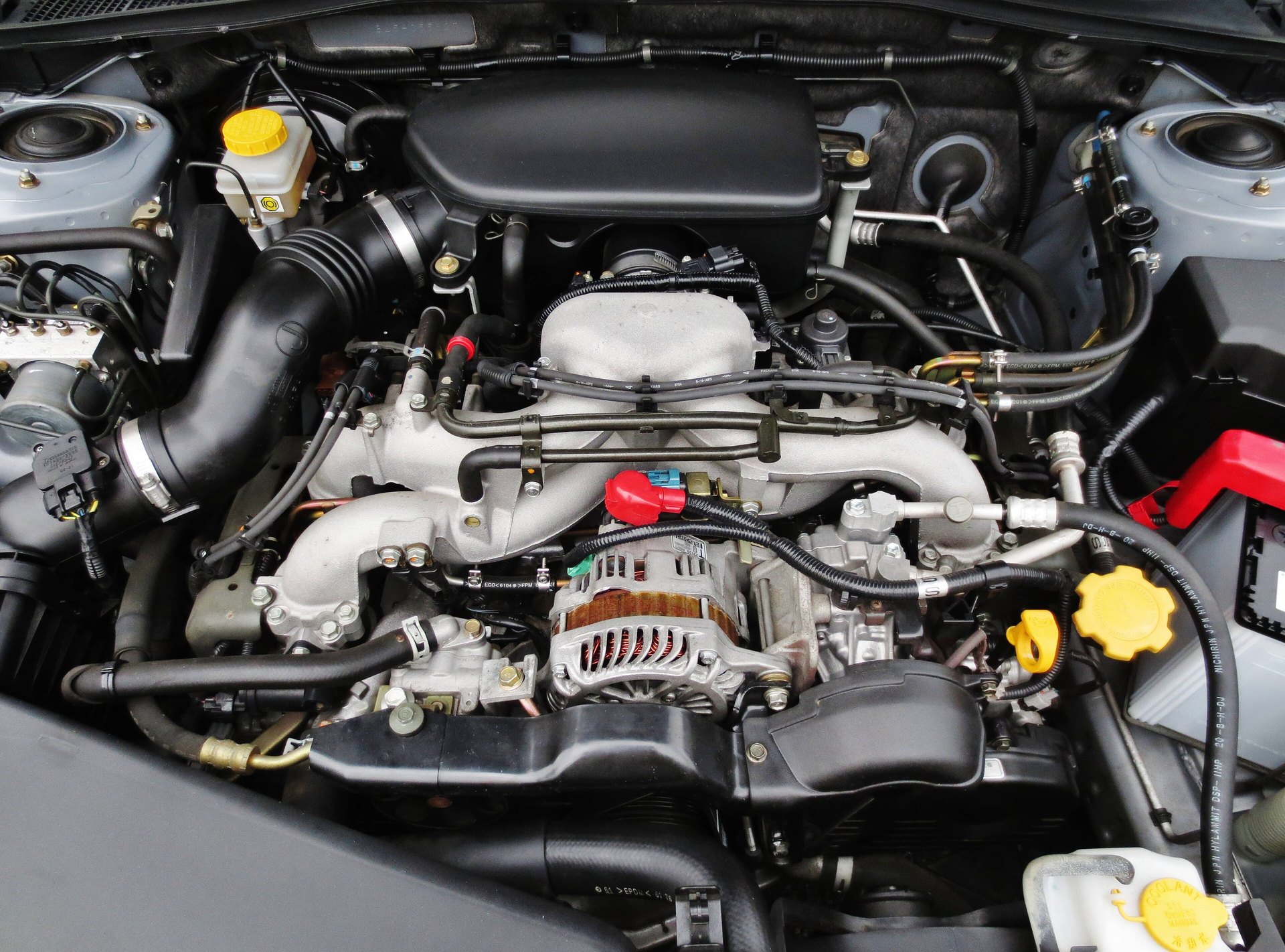 Двигатель Subaru EJ20 SOHC под капотом Legacy B4, видны высоковольтные провода